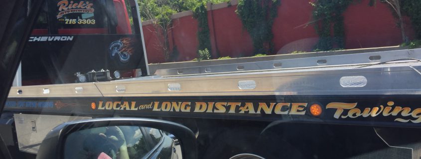 Tow truck lettering is visible on the Long Island Expressway every day