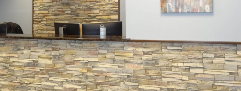 Faux stone in office reception area and behind acrylic logo signage.