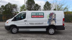 vinyl graphics and watercolor-style illustration are striking on the side of a white van.