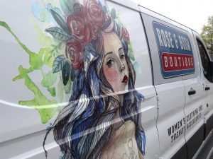 Close-up of watercolor-style illustration in vinyl on a white van.