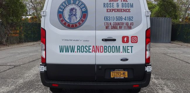 Perforated vinyl on the back window of a van advertises the Rose & Bloom Experience.