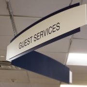 Double paneled suspended Guest Services sign